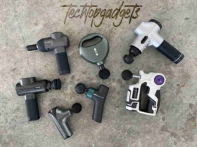 A diverse collection of massage guns laid out on a surface, each competing for the title of best budget massage gun with their unique features and designs.