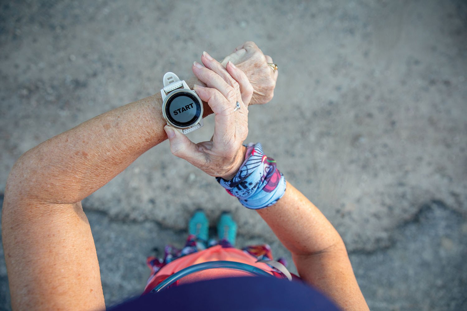 An individual preparing to start their workout routine, checking the 'START' button on their fitness watch, symbolizing the role of technology in active lifestyles.