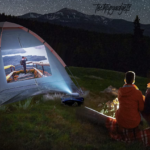 Two campers enjoy a serene night under the stars, with a portable projector displaying a vivid image on their tent. This setup exemplifies the best portable projector for camping, creating an unforgettable outdoor theater experience.