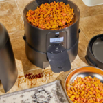 The Petlibro Automatic Pet Feeder is pictured in a home environment, illustrating why it's considered one of the best automatic pet feeders with its dual-bowl design and timer display for scheduled feeding.