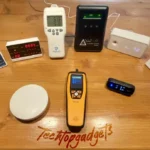 A collection of the best indoor air quality monitors for mold lined up on a wooden table, showcasing a variety of designs and capabilities for ensuring healthy indoor air.