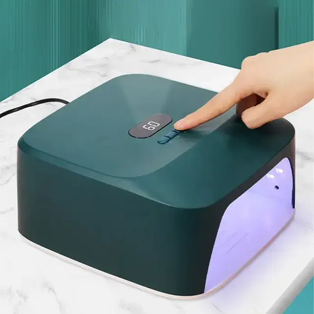 A person using a modern nail dryer, showcasing the innovative features of nail dryers as a part of nail dryer tips and tricks for a perfect manicure.