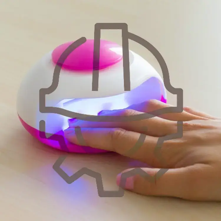 A hand placed under a dome-shaped UV nail dryer emitting purple light, illustrating the advanced nail dryer features for quick and even curing.