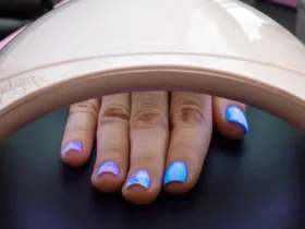 Wide professional nail dryer in a salon setting, with a hand inside, highlighting its nail dryer features, designed for high-quality nail art curing.